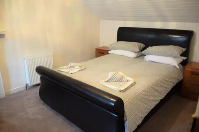 a large bed with two towels on top of it at The Stables in Carsethorn