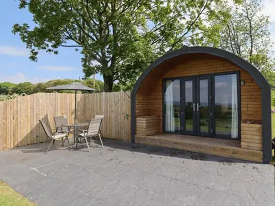 a gazebo with a table and chairs on a patio at Dryfe Lodge in Lockerbie