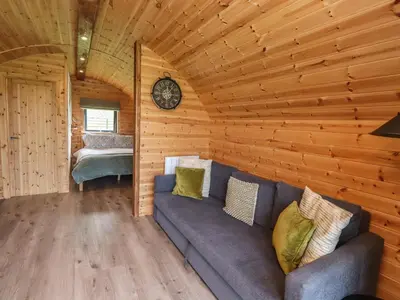 a living room with a couch in a log cabin at Dryfe Lodge in Lockerbie