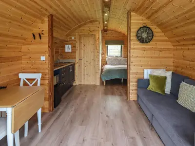 a room in a log cabin with a couch and a table at Dryfe Lodge in Lockerbie