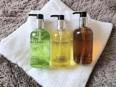 three bottles of cleaning products sitting on a towel at Herdwick Guest House in Keswick