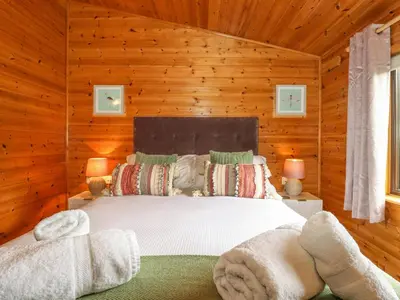 a bedroom with a bed in a wooden room at Derwent Lodge in Keswick