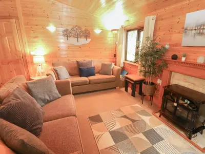 a living room with a couch and a fireplace at Derwent Lodge in Keswick