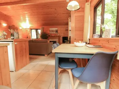 a kitchen and living room with a table and chairs at Derwent Lodge in Keswick