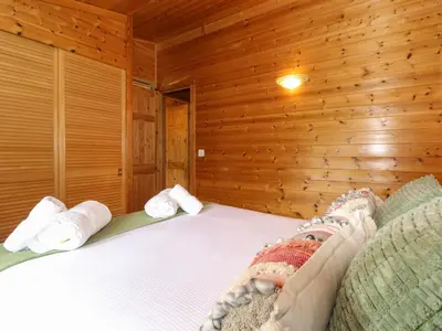a bedroom with a bed in a wooden wall at Derwent Lodge in Keswick