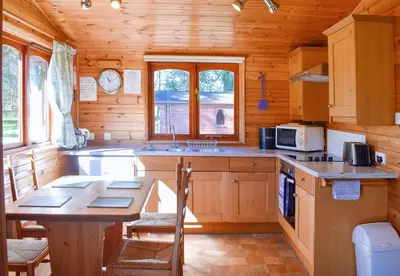 a kitchen with a table in a wooden cabin at Secluded Pine Lodge 2 in Wigton