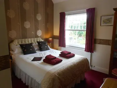 a bedroom with a bed with red towels on it at Skiddaw Grove in Keswick
