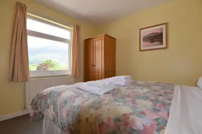a bedroom with a bed and a window at Skiddaw Grove in Keswick