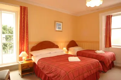 a hotel room with two beds with red sheets at Skiddaw Grove in Keswick
