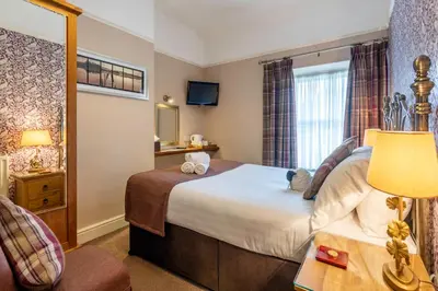 a hotel room with a bed and a window at Avondale Guest House in Keswick