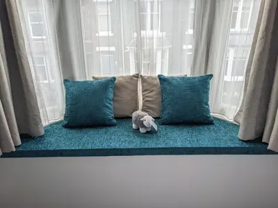 a stuffed elephant sitting on a couch in a window at Avondale Guest House in Keswick