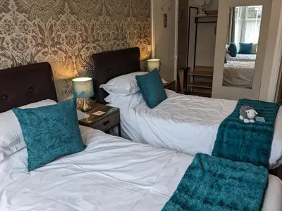 a bedroom with two beds with green pillows at Avondale Guest House in Keswick