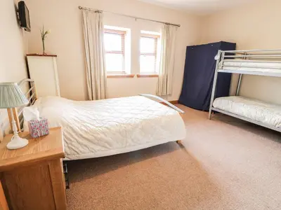 a bedroom with two bunk beds and a desk at Laird House in Lockerbie