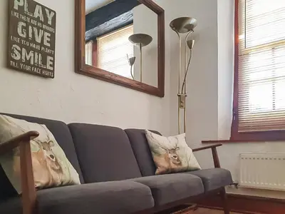 a living room with a gray couch and a mirror at Market Place in Workington