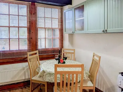 a dining room with a table and chairs and windows at Market Place in Workington