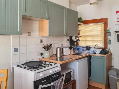 a kitchen with green cabinets and a stove top oven at Market Place in Workington