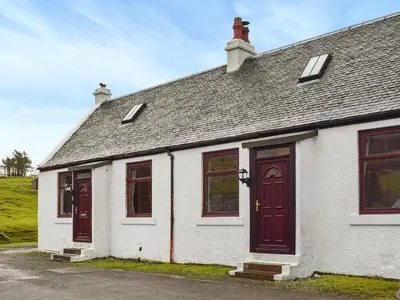 a white house with red doors and windows at Winlocke Cottage in Leadhills