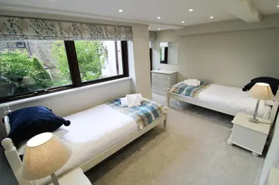 a bedroom with two beds and a window at Brae Fell Cottage, Sebergham, Nr Caldbeck dog friendly and hot tub in Sebergham