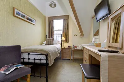 a bedroom with a bed and a sink and a television at The Edwardene in Keswick