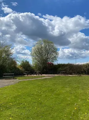 a park with benches and a field of grass at The Fenwick Hotel in Kilmarnock