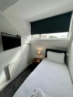 a small bedroom with a bed and a window at Waverley Hotel in Workington