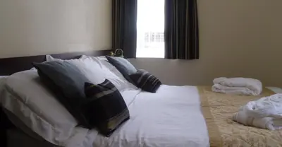 a bedroom with a bed with pillows and a window at Waverley Hotel in Workington