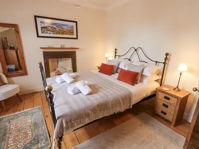 a bedroom with a bed with pillows and a fireplace at Primrose Cottage in Keswick