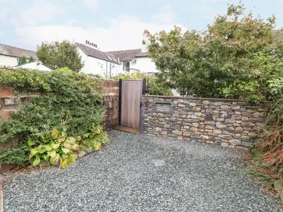 a gate in a stone wall with a door at Primrose Cottage in Keswick
