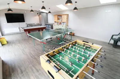 a room with two ping pong tables and a tv at Cloven Stone, Nr Caldbeck ideal family accommodation with hot tub in Sebergham