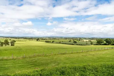 a field of green grass with a fence at Fisher Gill, Sebergham, Close to Caldbeck Fells with hot tub in Sebergham