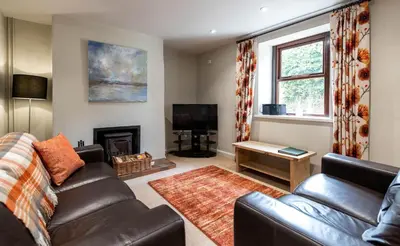 a living room with a couch and a fireplace at Fisher Gill, Sebergham, Close to Caldbeck Fells with hot tub in Sebergham