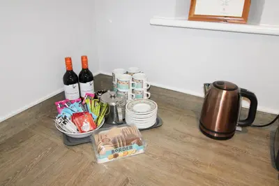 a table with a coffee pot and wine bottles and dishes at Great Calva, Sebergham, perfect for 2 families or friends with 3 dogs welcome and hot tub in Sebergham