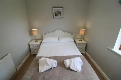 a bedroom with a bed with two towels on it at Great Calva, Sebergham, perfect for 2 families or friends with 3 dogs welcome and hot tub in Sebergham