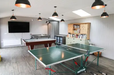 a room with two ping pong tables and a tv at Great Calva, Sebergham, perfect for 2 families or friends with 3 dogs welcome and hot tub in Sebergham