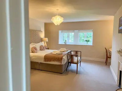 a bedroom with a bed and a table and a window at High House, Southwaite in a rural setting with countryside views, garden with BBQ & hot tub in Southwaite