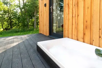 a bath tub sitting on a wooden deck at Ruecroft, Penruddock an Eco & dog friendly lodge with a hot tub, 10 minutes from Lake Ullswater in Penruddock