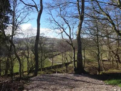 a path through the trees on the tissington trail at Ruecroft, Penruddock an Eco & dog friendly lodge with a hot tub, 10 minutes from Lake Ullswater in Penruddock