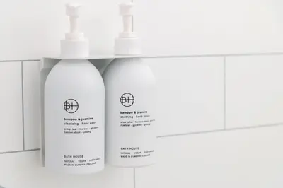 two white bottles ofodorizers are sitting on a shelf at Ruecroft, Penruddock an Eco & dog friendly lodge with a hot tub, 10 minutes from Lake Ullswater in Penruddock