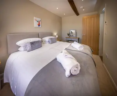 a bedroom with a large white bed with towels on it at The Farmhouse, Sebergham, spacious family or group accommodation in a rural setting close to Caldbeck in Sebergham