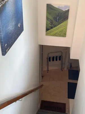 a hallway with two paintings on the wall and a stairway at Little Limetree in Moffat