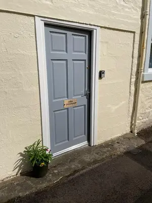 a blue door with a sign in front of it at Little Limetree in Moffat