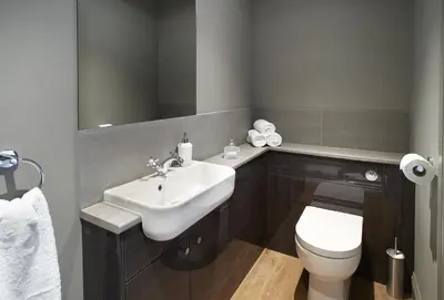a bathroom with a sink and a toilet and a mirror at Netherwood Lodge in Dumfries