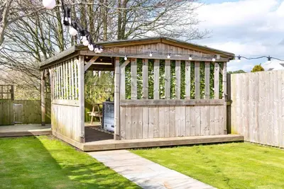 a wooden gazebo in a garden at Cottage - Sleeps 3 hot tub & pet friendly in Carlisle