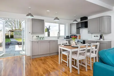 a kitchen with white cabinets and a table and chairs at Cottage - Sleeps 3 hot tub & pet friendly in Carlisle
