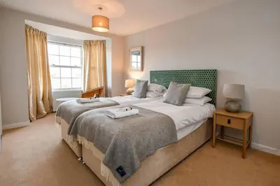 a bedroom with a large bed and a window at 3 bedroom townhouse right on the harbour in Isle of Whithorn
