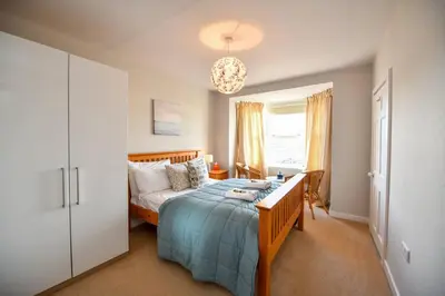 a bedroom with a bed and a desk in it at 3 bedroom townhouse right on the harbour in Isle of Whithorn