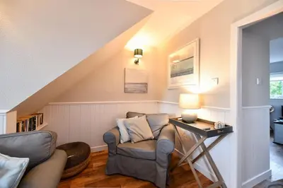 a living room with a chair and a table at 3 bedroom townhouse right on the harbour in Isle of Whithorn