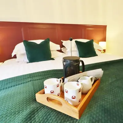 a tray with cups and a pitcher on a bed at 14 Union Street in Kirkcudbright