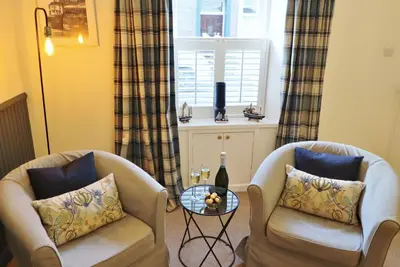 a living room with two chairs and a window at 14 Union Street in Kirkcudbright