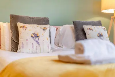 a close up of a bed with pillows at Redwood Rise Apartment Keswick at The Lairbeck in Keswick
